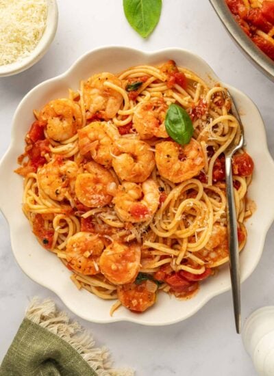 A bowl of pasta topped with sauteed shrimp.