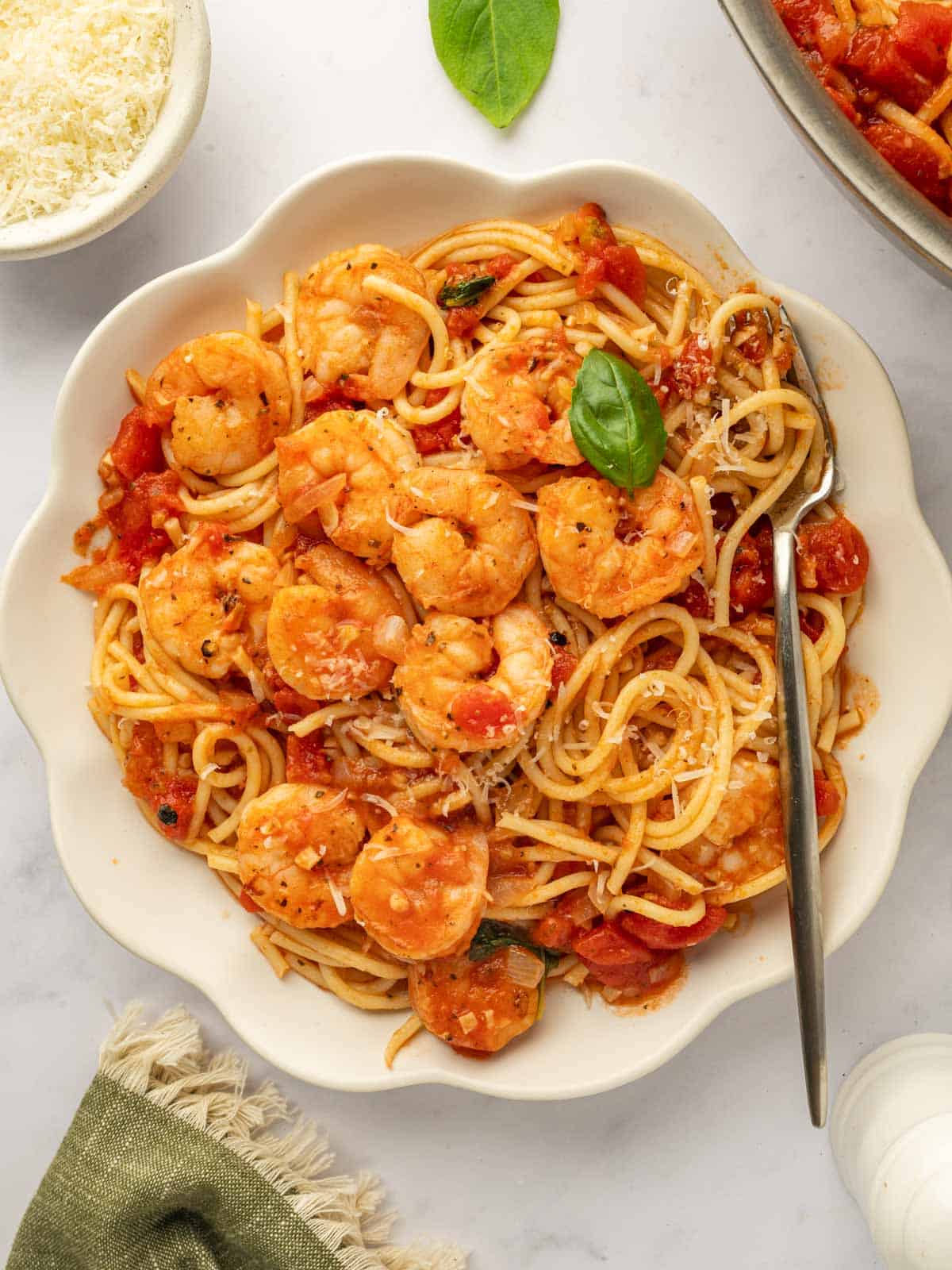 A bowl of pasta topped with sauteed shrimp.