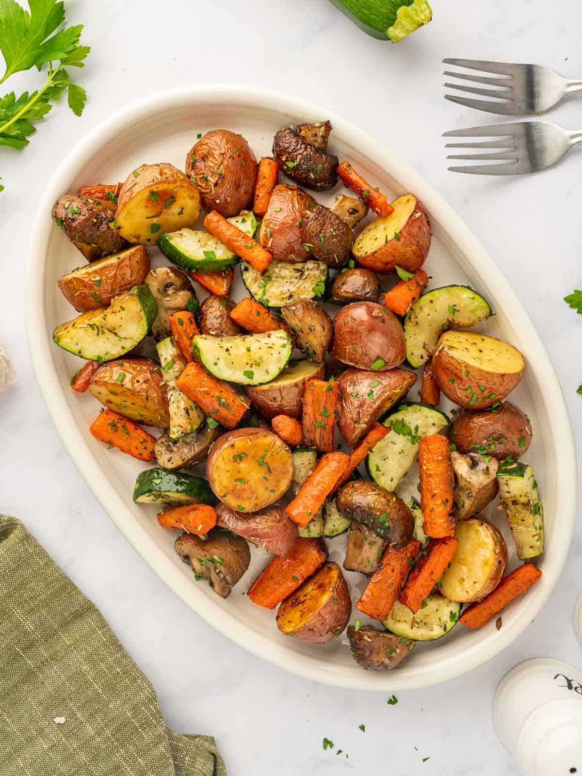 A large platter is filled with oven roasted vegetables.