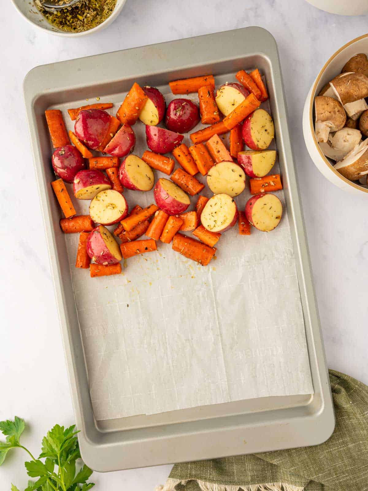 Root veggies added to a baking sheet.