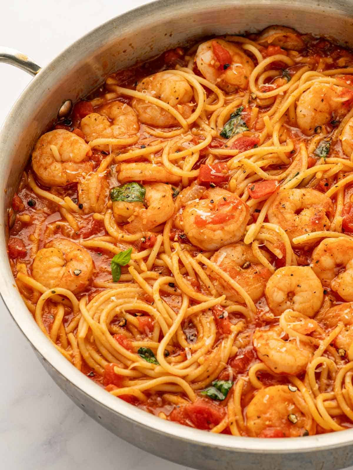 A closeup view of a skillet of shrimp pasta.