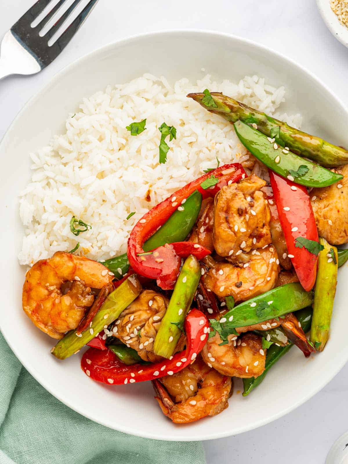 A plate of shrimp and chicken stir fry with rice.