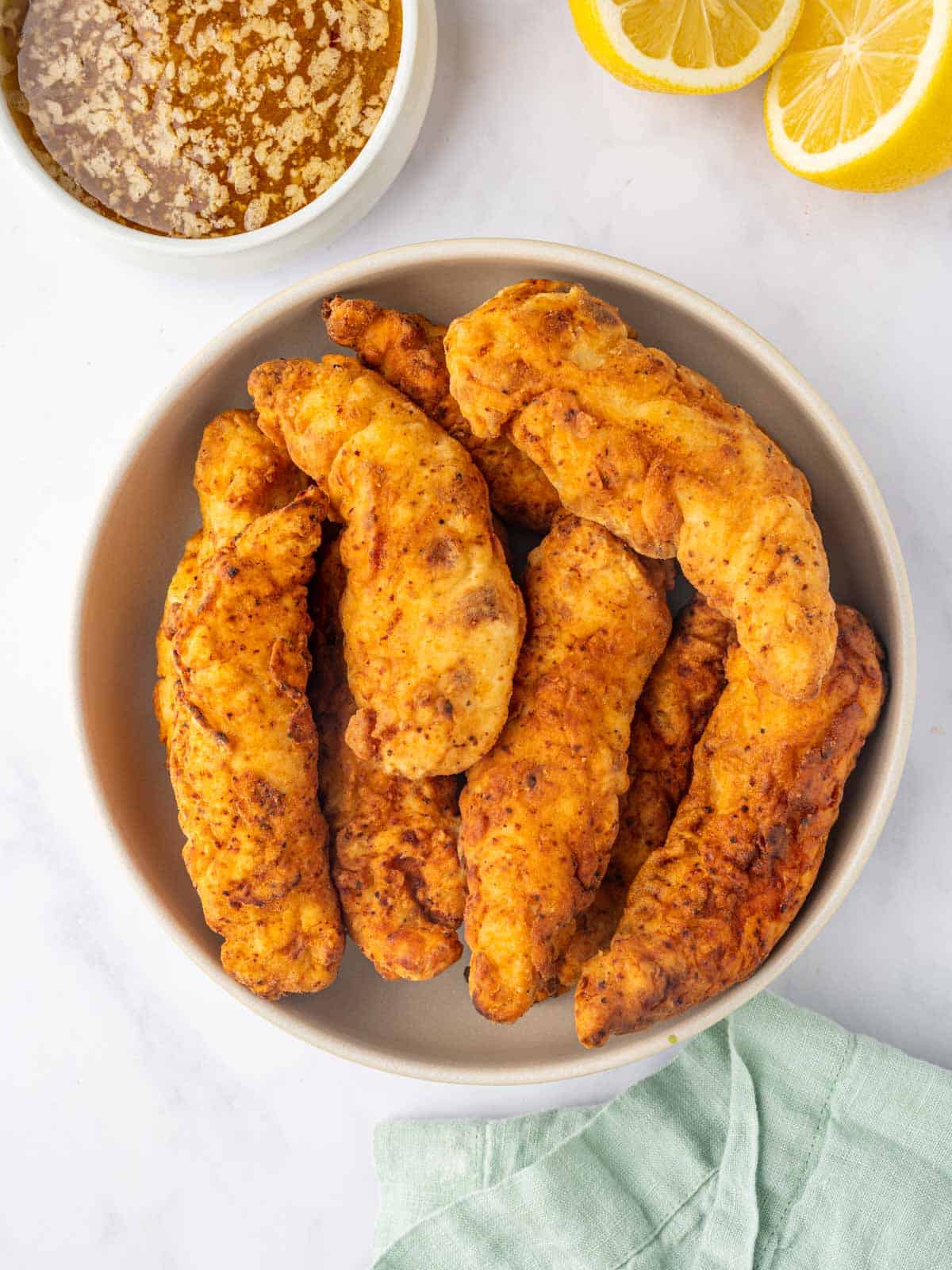 Cooked chicken strips in a bowl.
