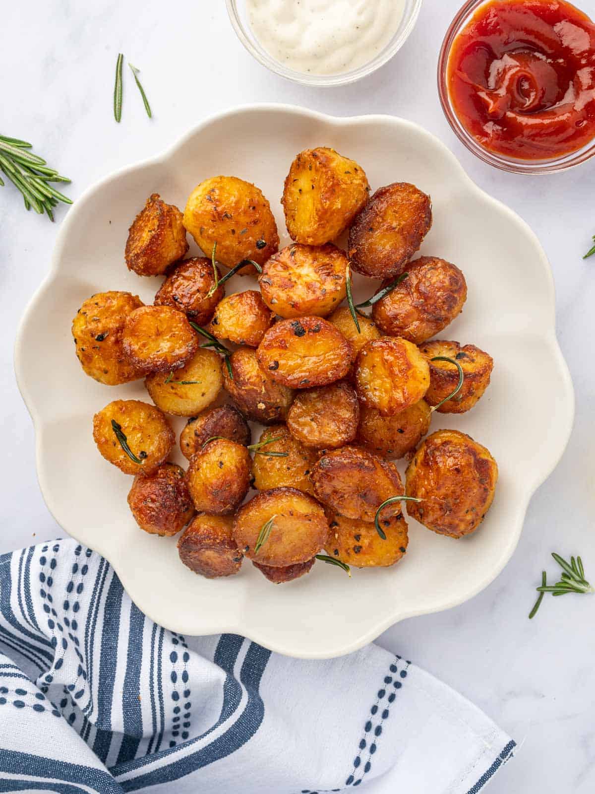 A platted of baked baby roasted potatoes with dipping sauces.