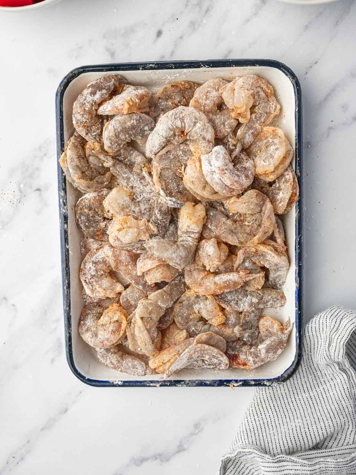 Shrimp is coated for pan frying.