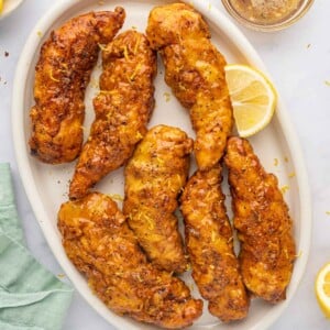 Lemon pepper chicken fingers on a platter.