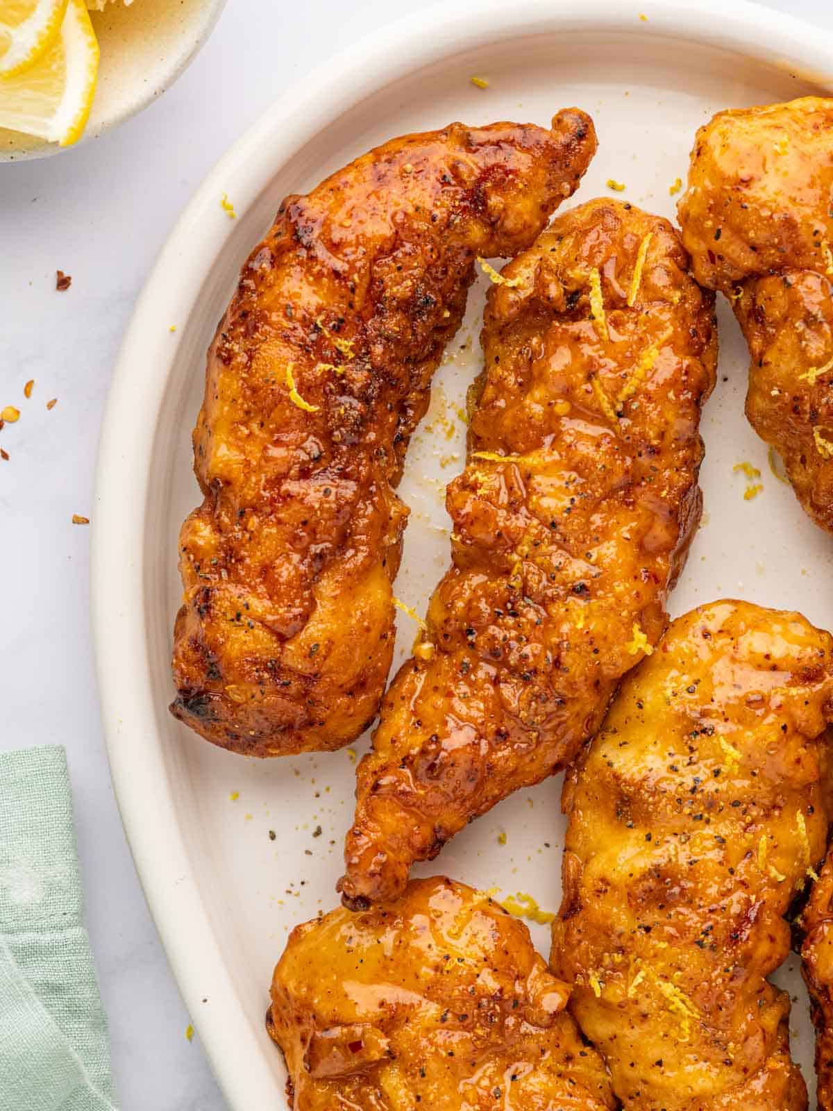 Crispy baked lemon pepper chicken strips with glaze.