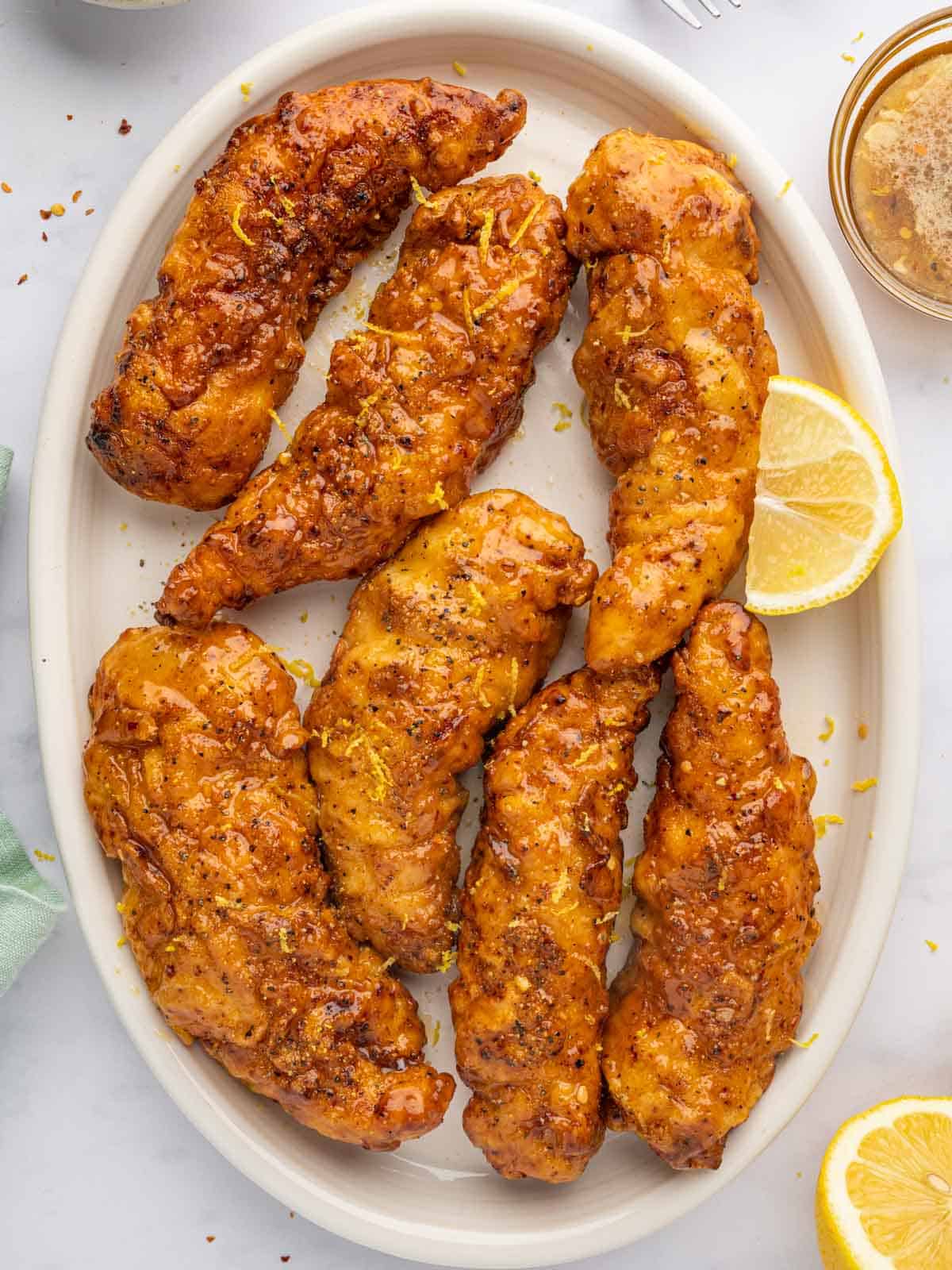 Crispy baked lemon pepper chicken strips with honey glaze.
