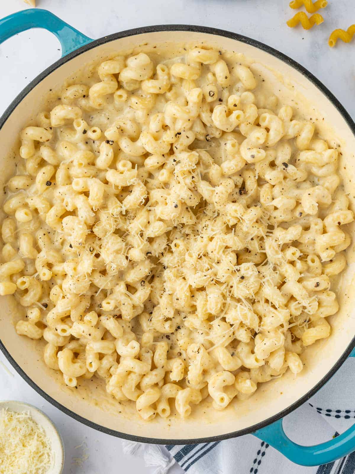 Top four cheese pasta with grated parmesan.