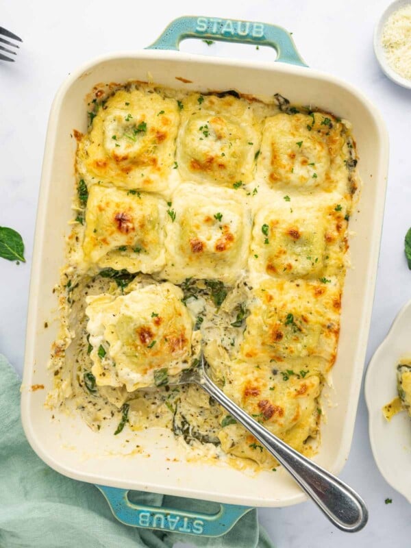 A spoon serves up a section of ravioli pasta bake.