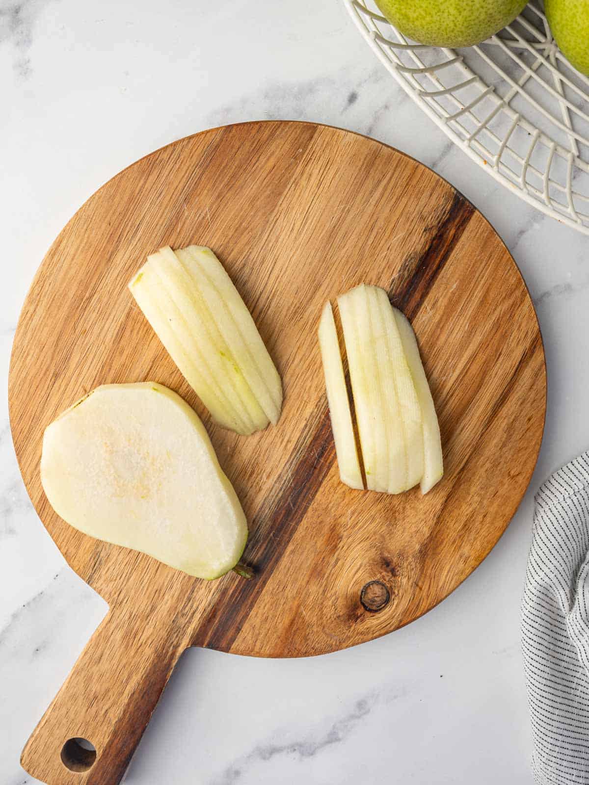 Thin slices of pears on a cutting board.