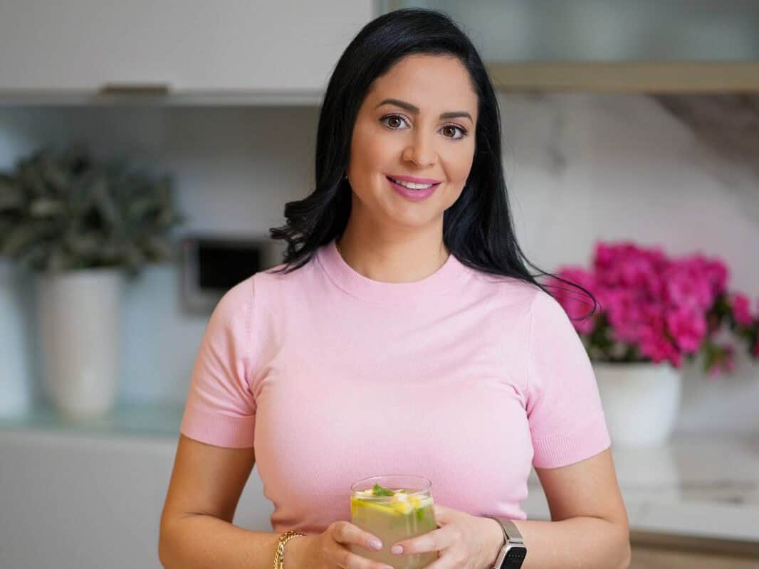 Mariam Ezzeddine from Cookin' With Mima Profile photo. Mariam wearing a pink shirt and holding a cup of lemonde. 