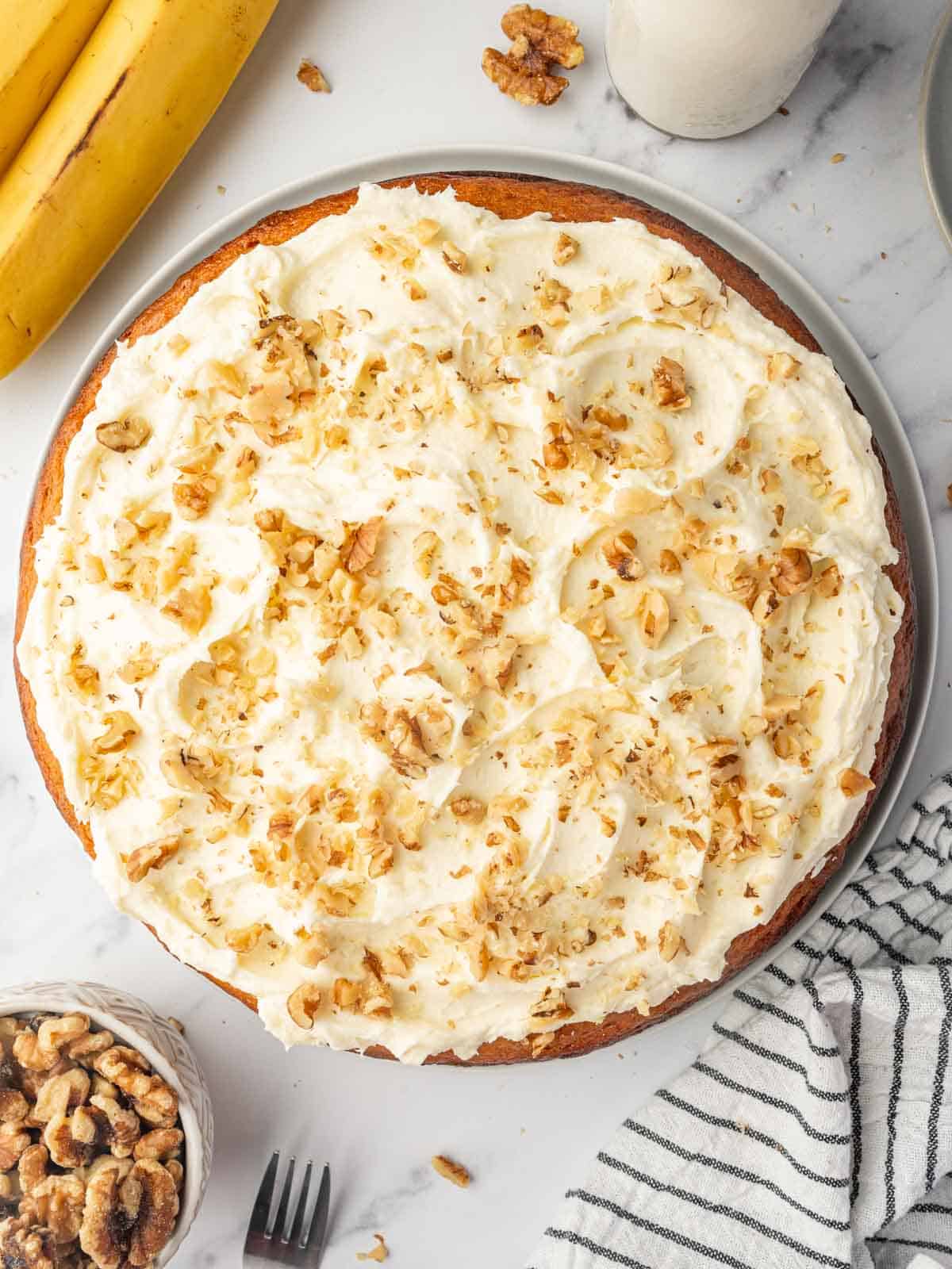 Top view of banana walnut cake on a platter.