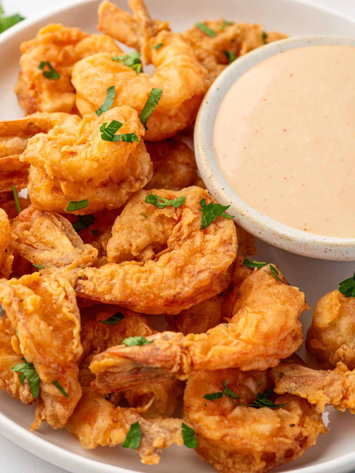 Plate of cajun fried shrimp with a bowl of dipping sauce of the side.