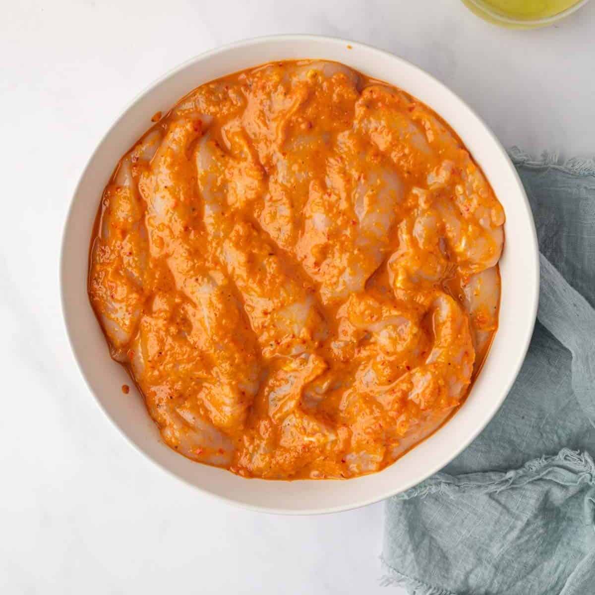 Chicken marinating in peri peri sauce.