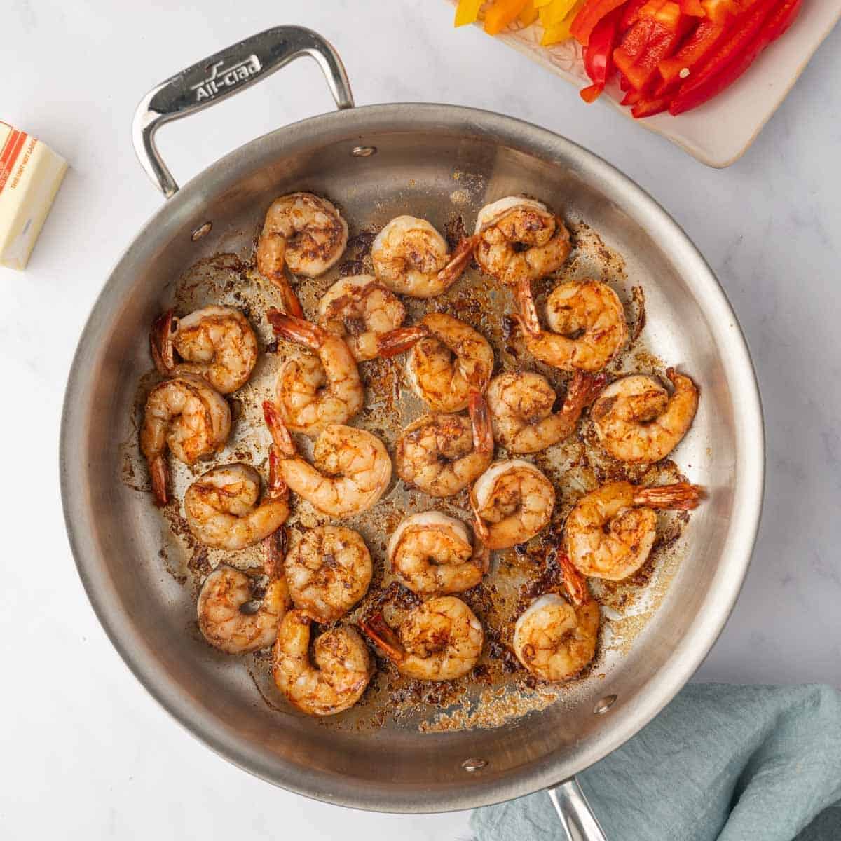 Shrimp is cooked in a skillet.