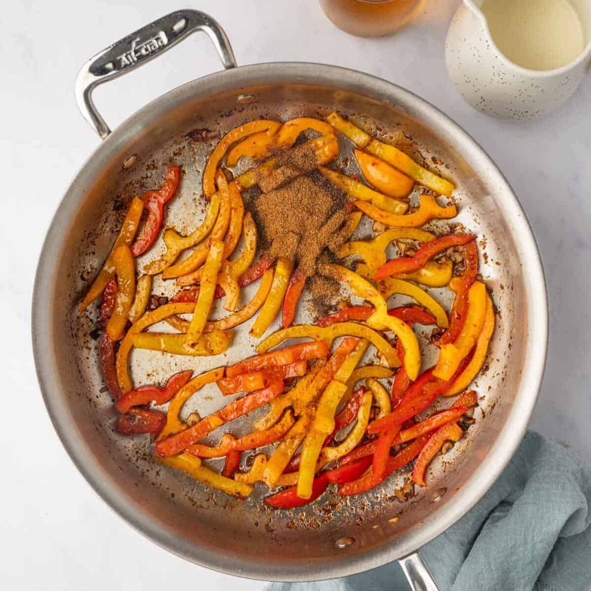 Jerk seasoning is added to sauted bell peppers.