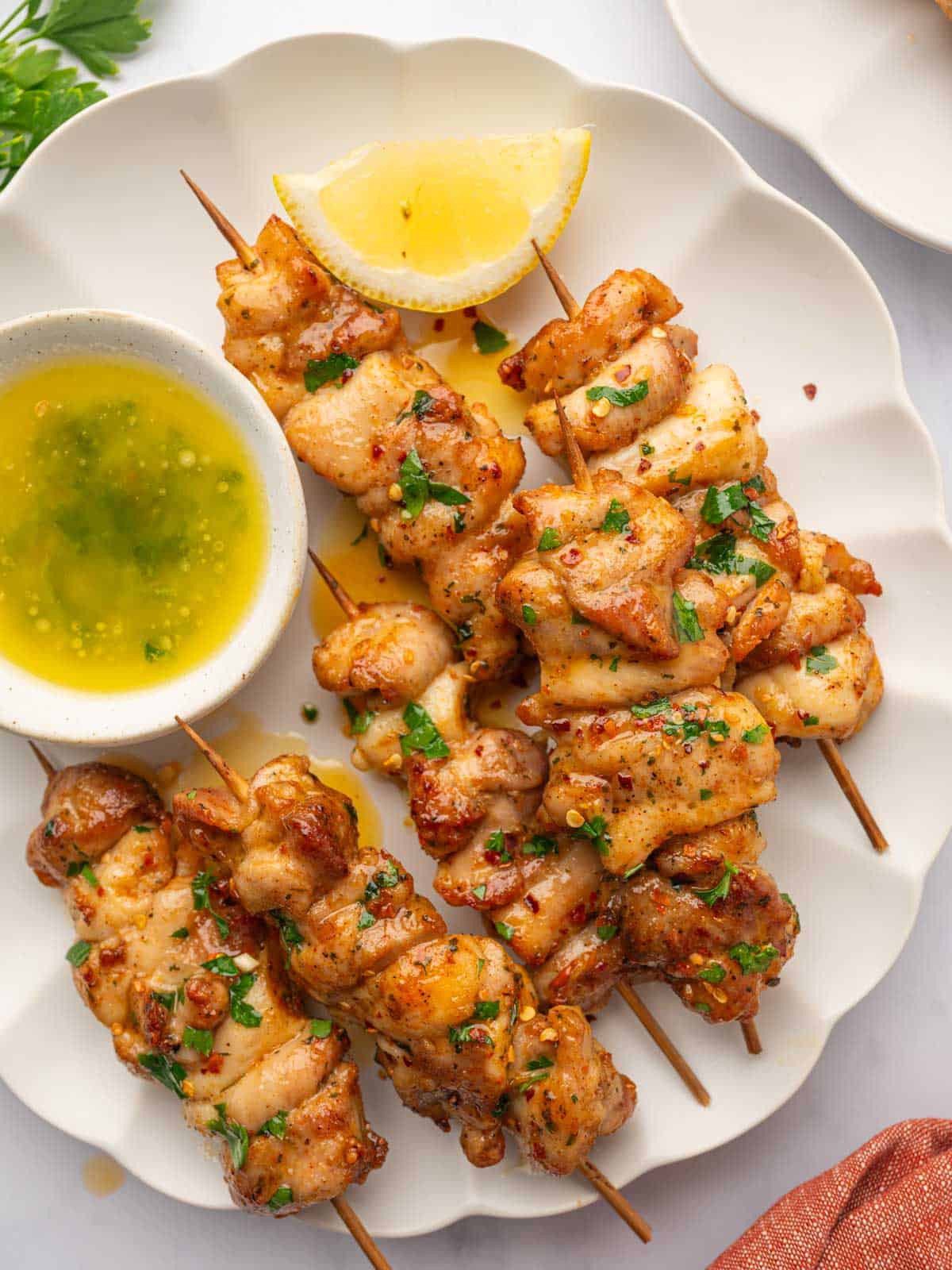 Close up of chicken skewers on a platter.