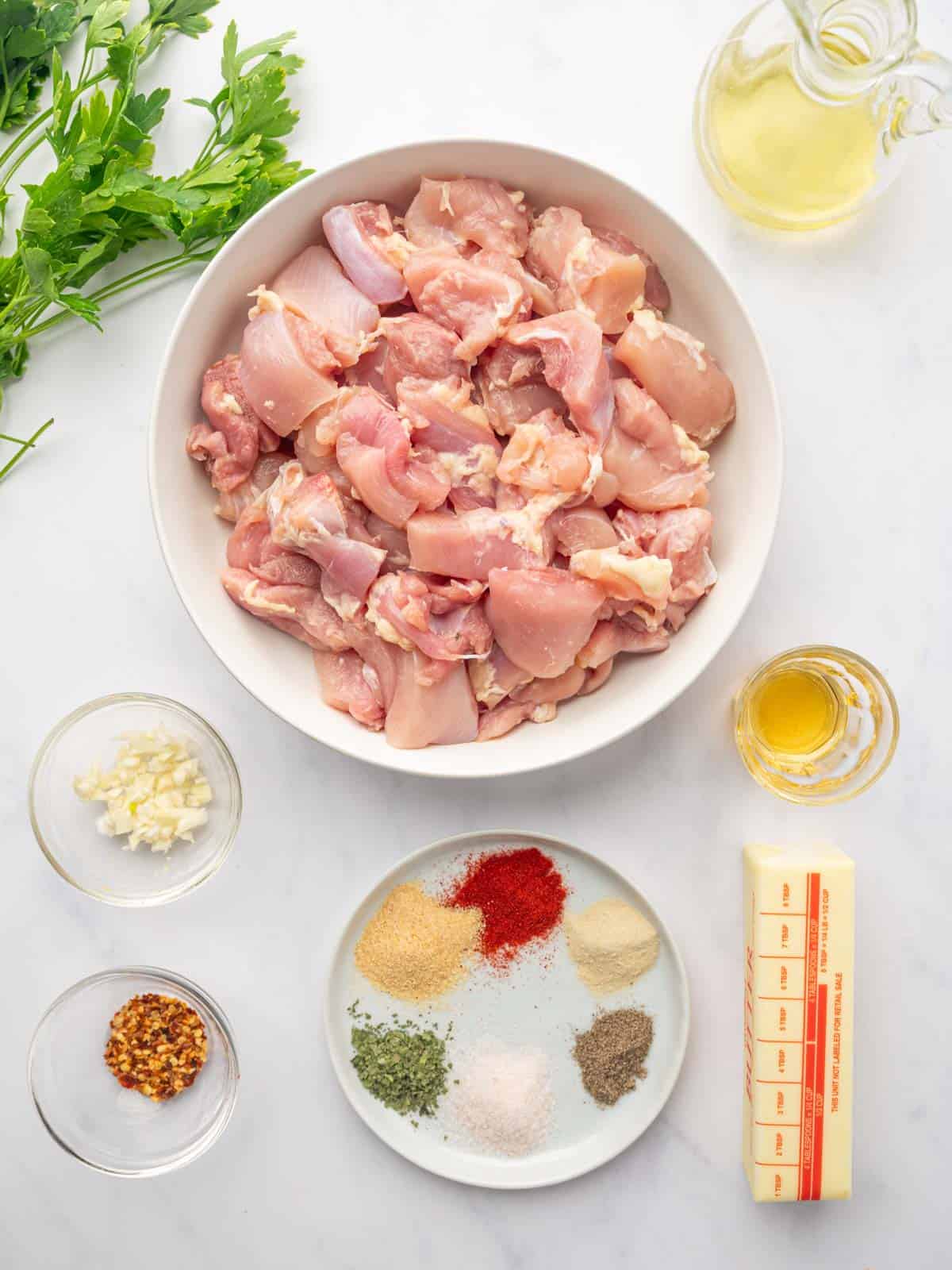 Ingredients needed for air fryer chicken skewers laid out on a white board.