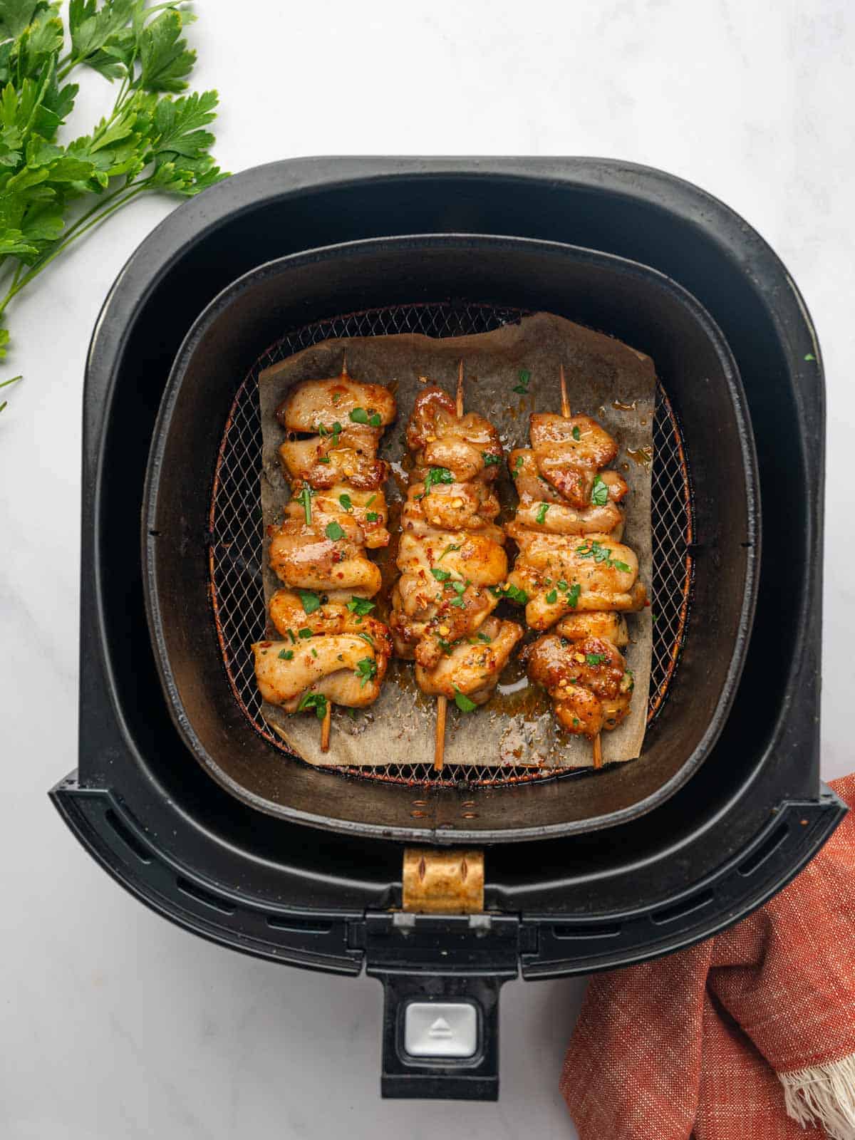 Air fryer chicken skewers in the basket.