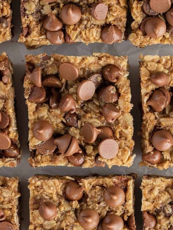 9 oatmeal bars topped with chocolate chips on a baking tray.