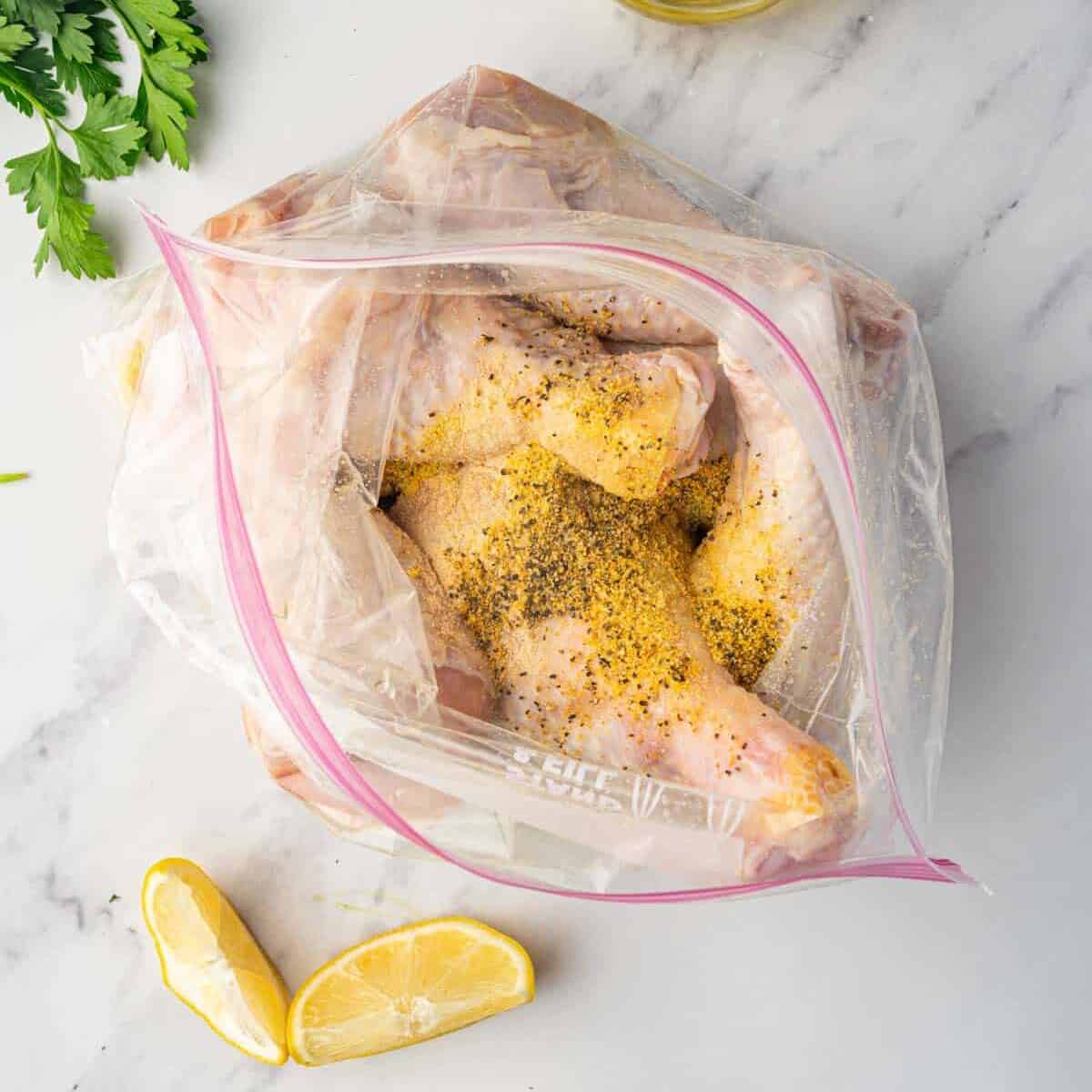 Lemon pepper marinade is added to a bag of chicken drumsticks.
