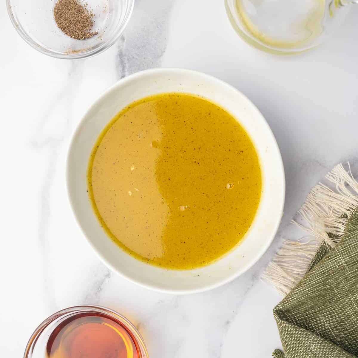 Maple citrus dressing is mixed in a small bowl.