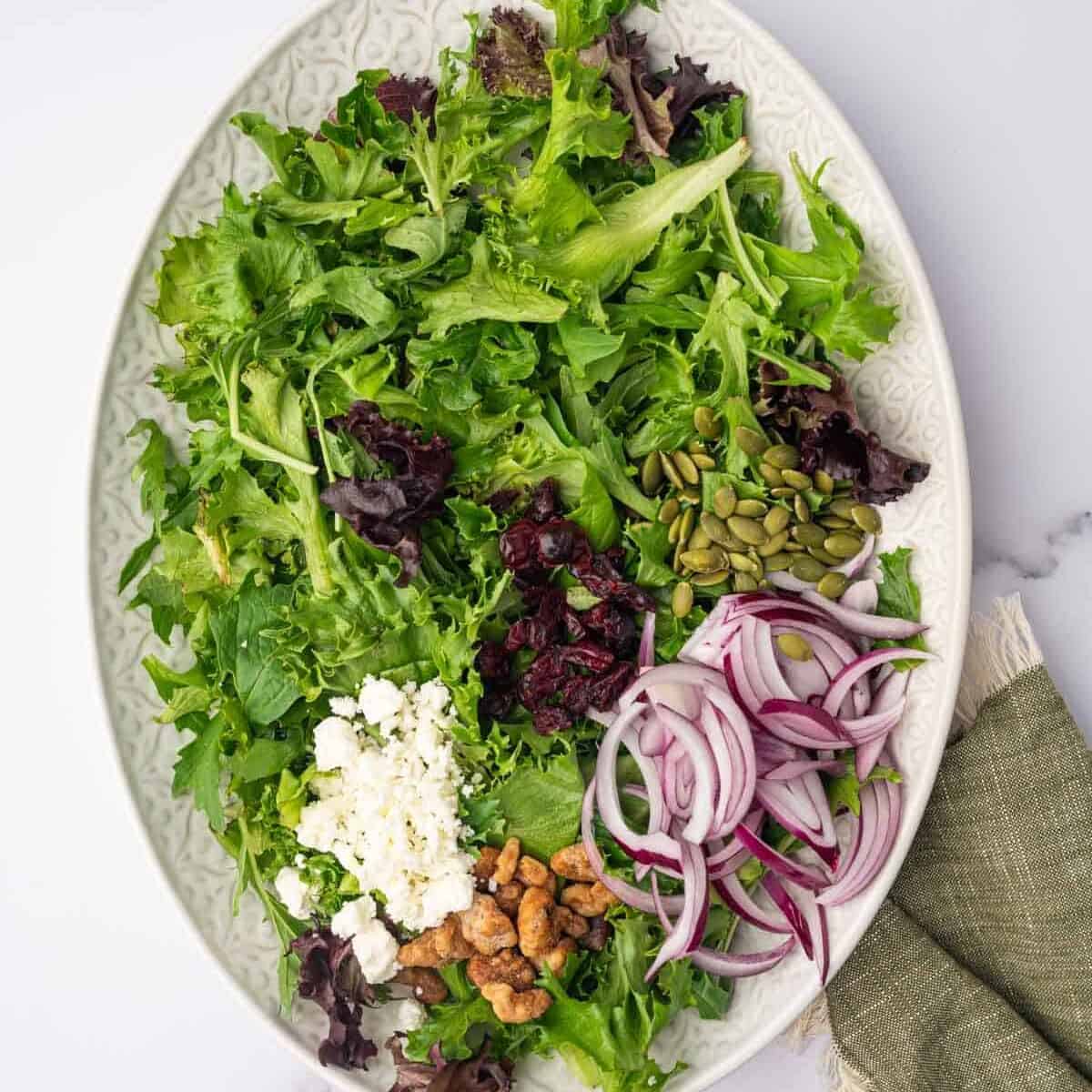 Salad ingredients are arranged on a large platter.