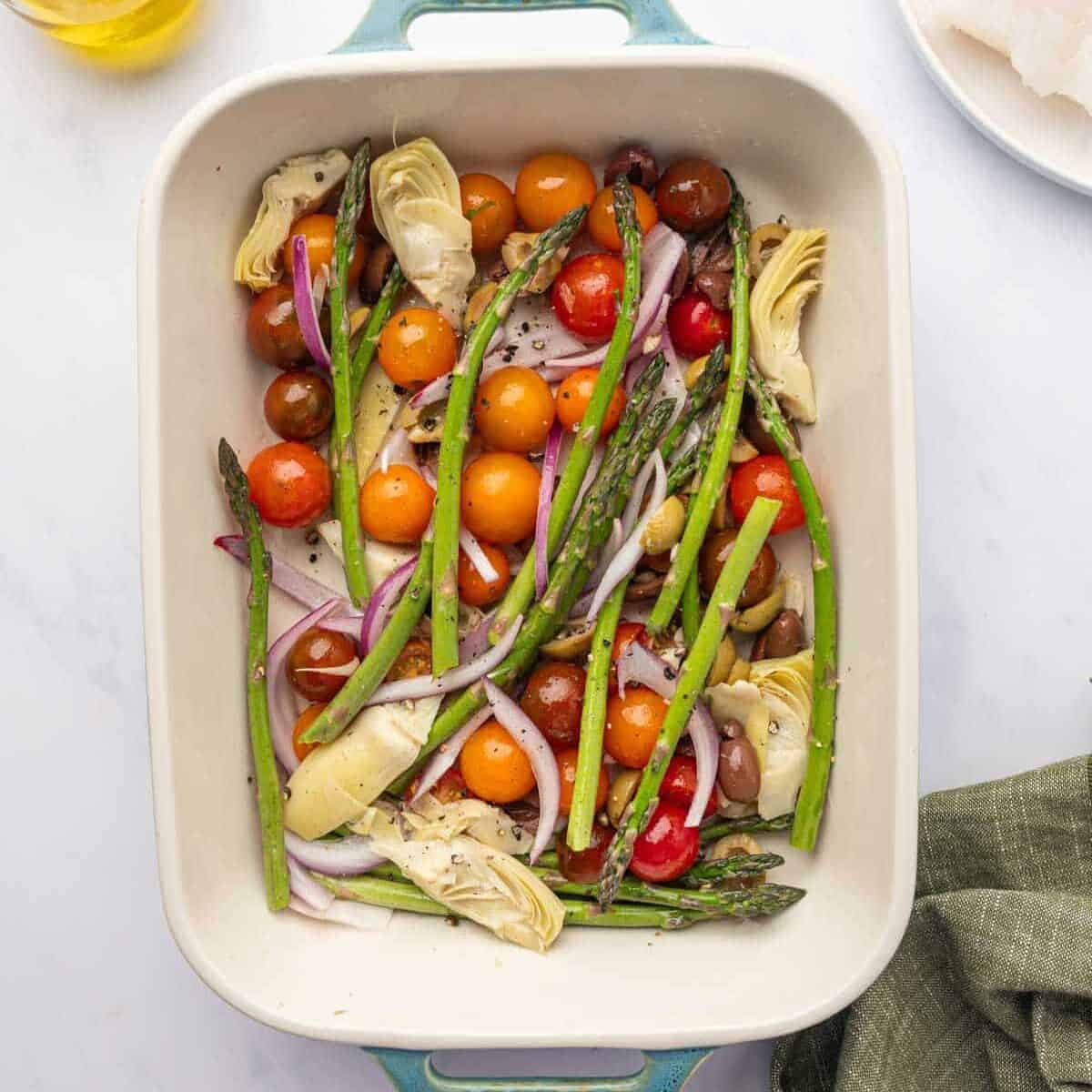 Vegetables are layered in a baking dish.