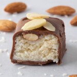 A coconut and almond filled candy bar is cut in half so you can see the filling.