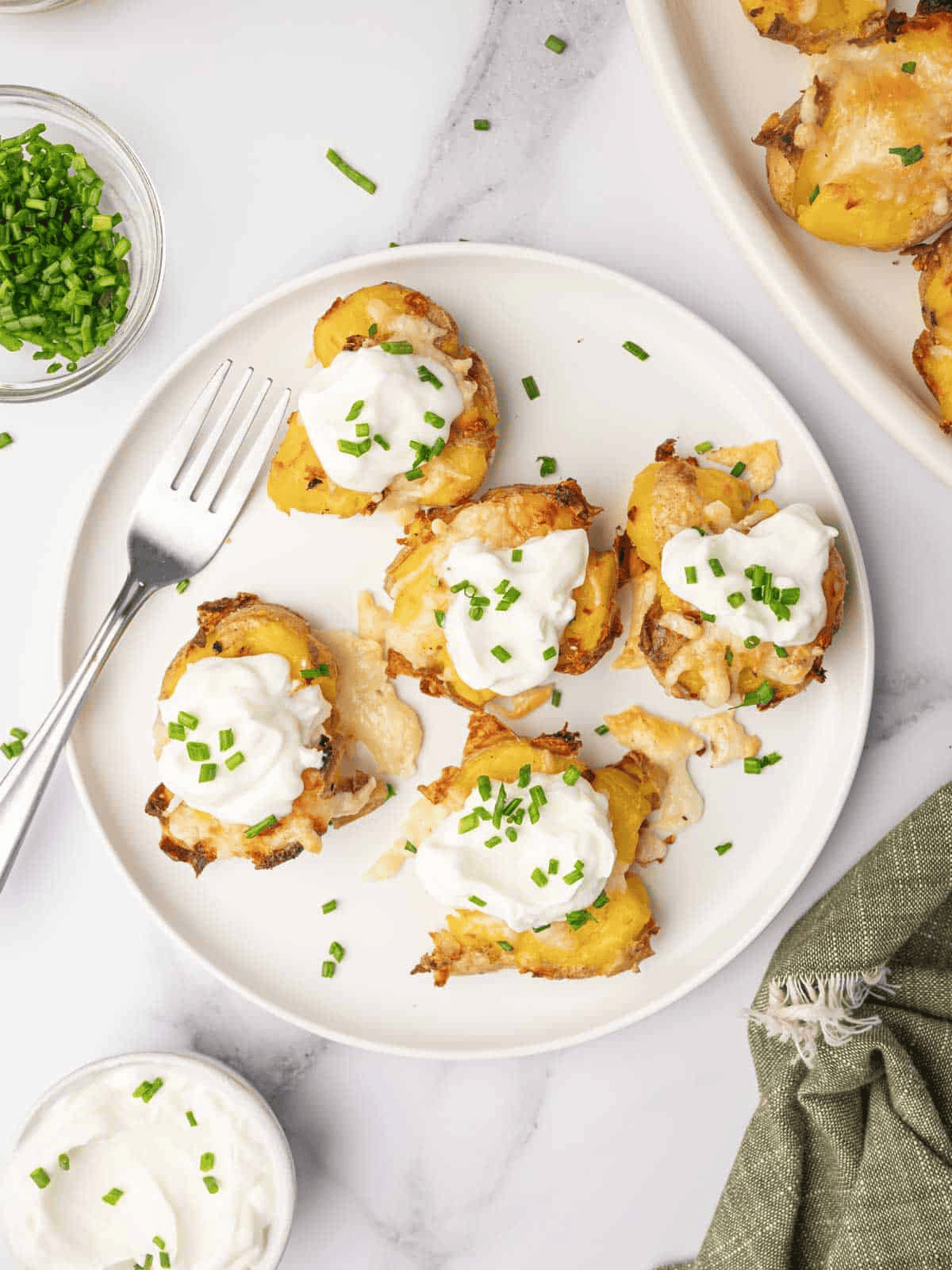 Crispy smashed potatoes served with dollops of sour cream and chopped fresh chives.