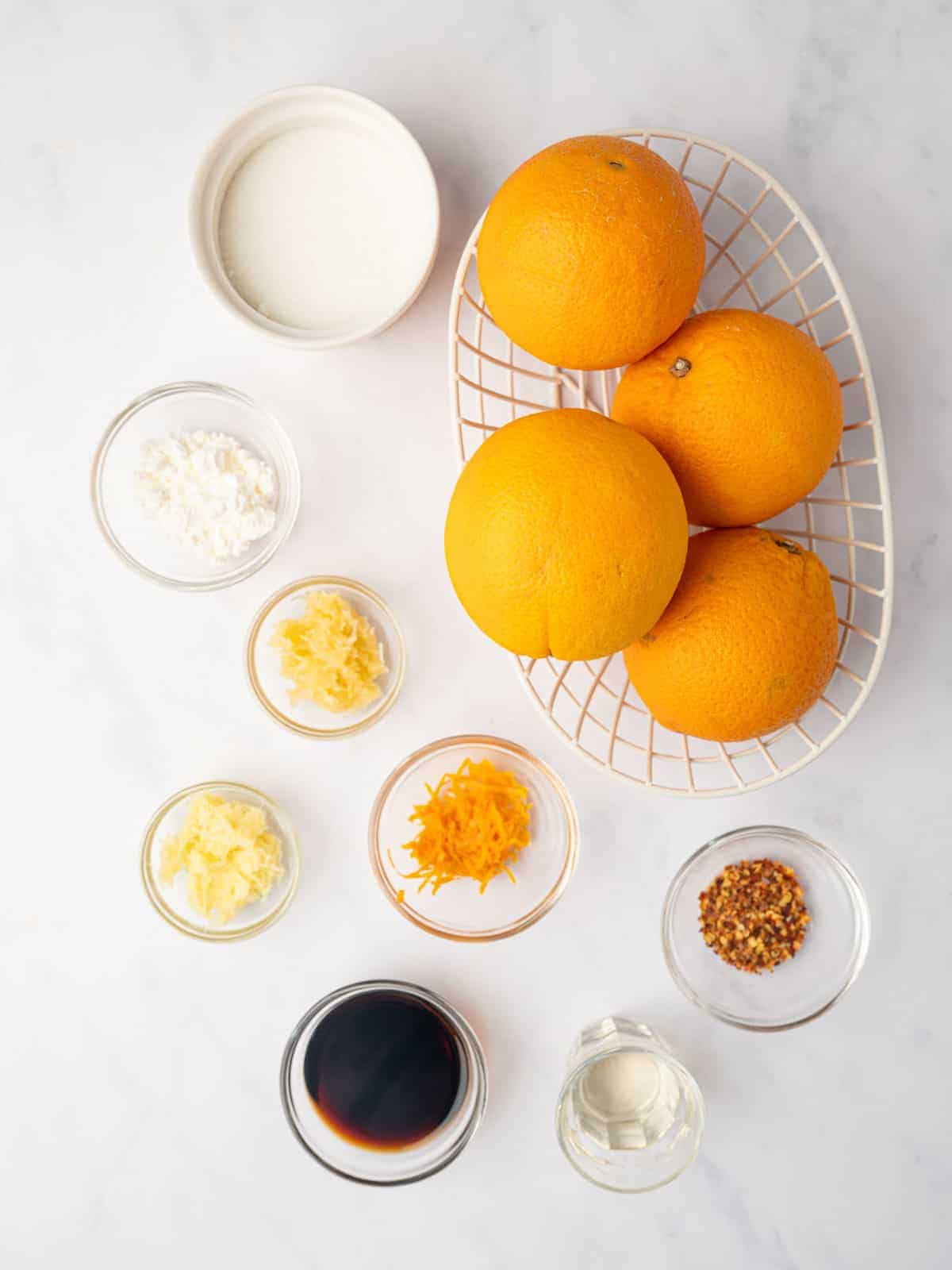 Ingredients for homemade orange sauce with fresh oranges, soy sauce, ginger, garlic, and seasonings.