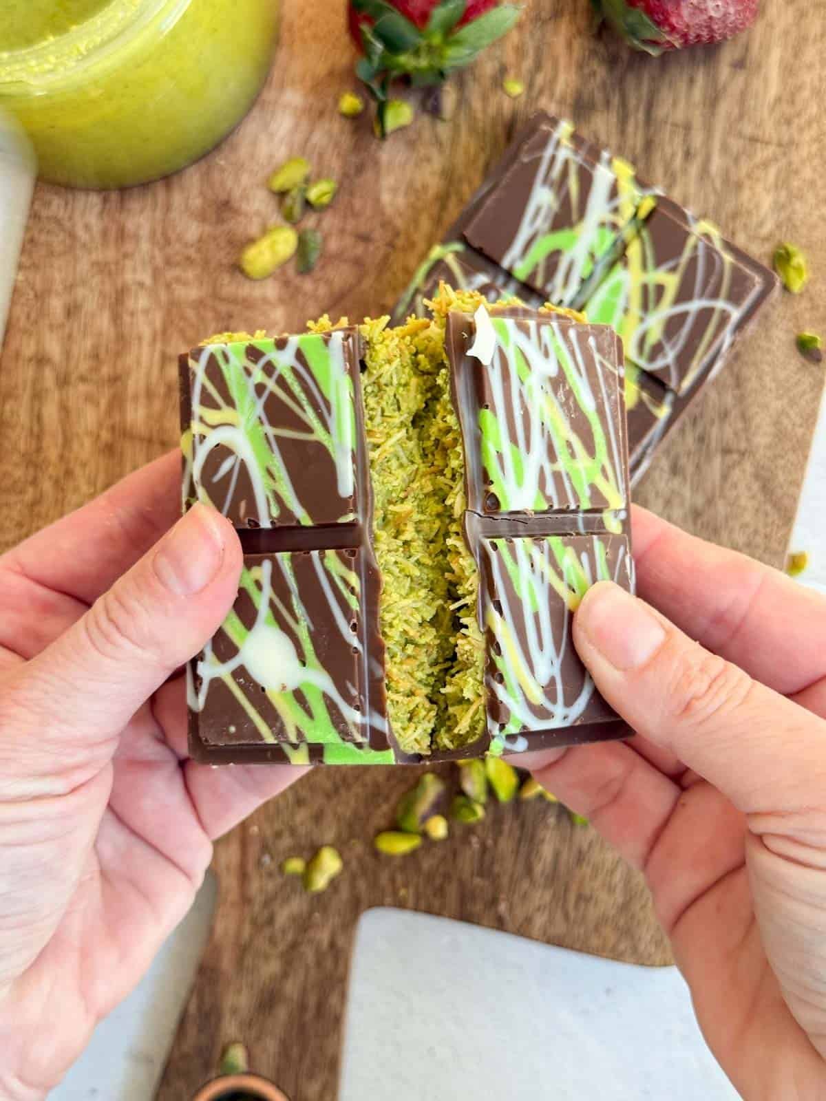 Hands breaking the Dubai Chocolate Bar.