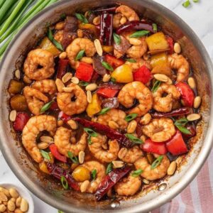 Kung Pao shrimp with bell peppers and peanuts in a skillet.