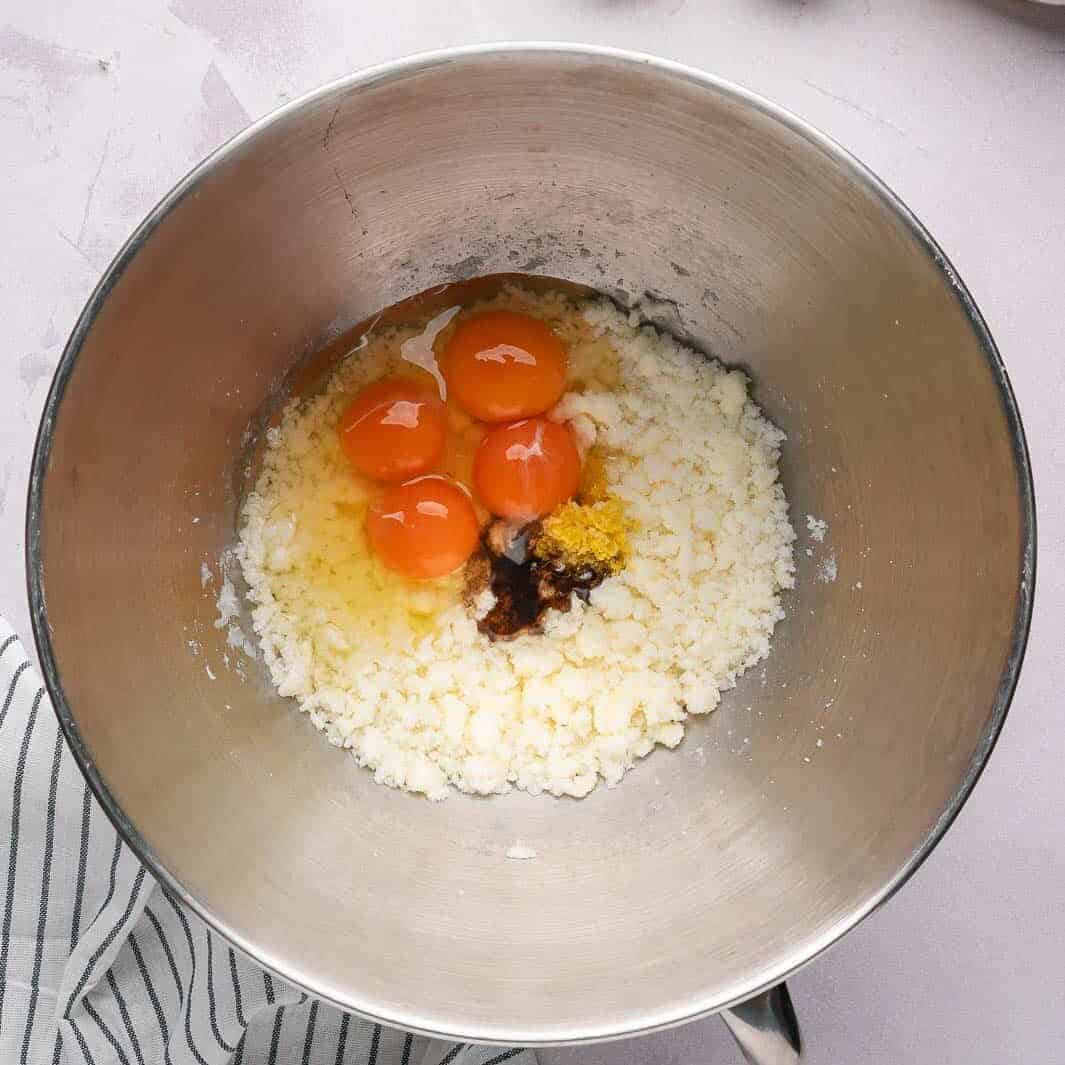 Incorporating room temperature eggs and vanilla extract into the buttery cake batter for an emulsified, silky texture.
