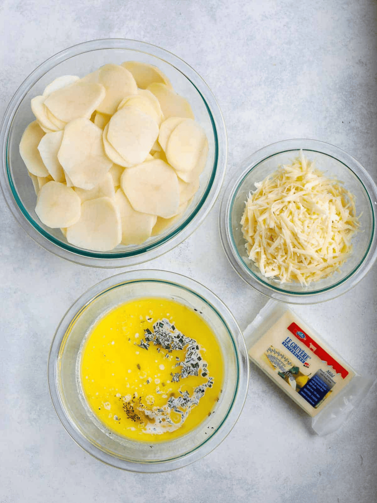 Sliced potatoes, shredded cheese, butter and seasoned cream for Au Gratin Potatoes.