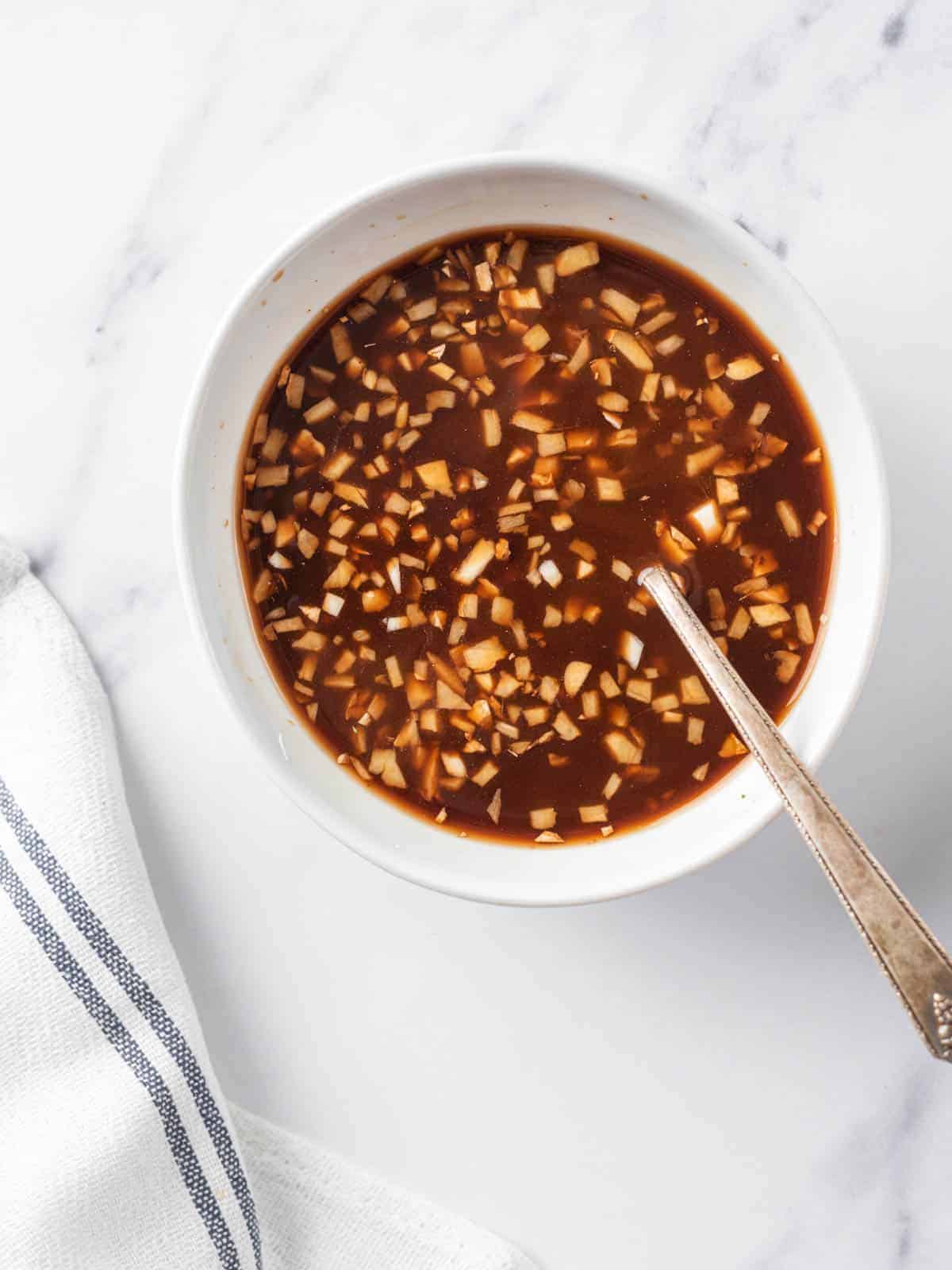 Kung Pao sauce with minced garlic and ginger in a bowl.