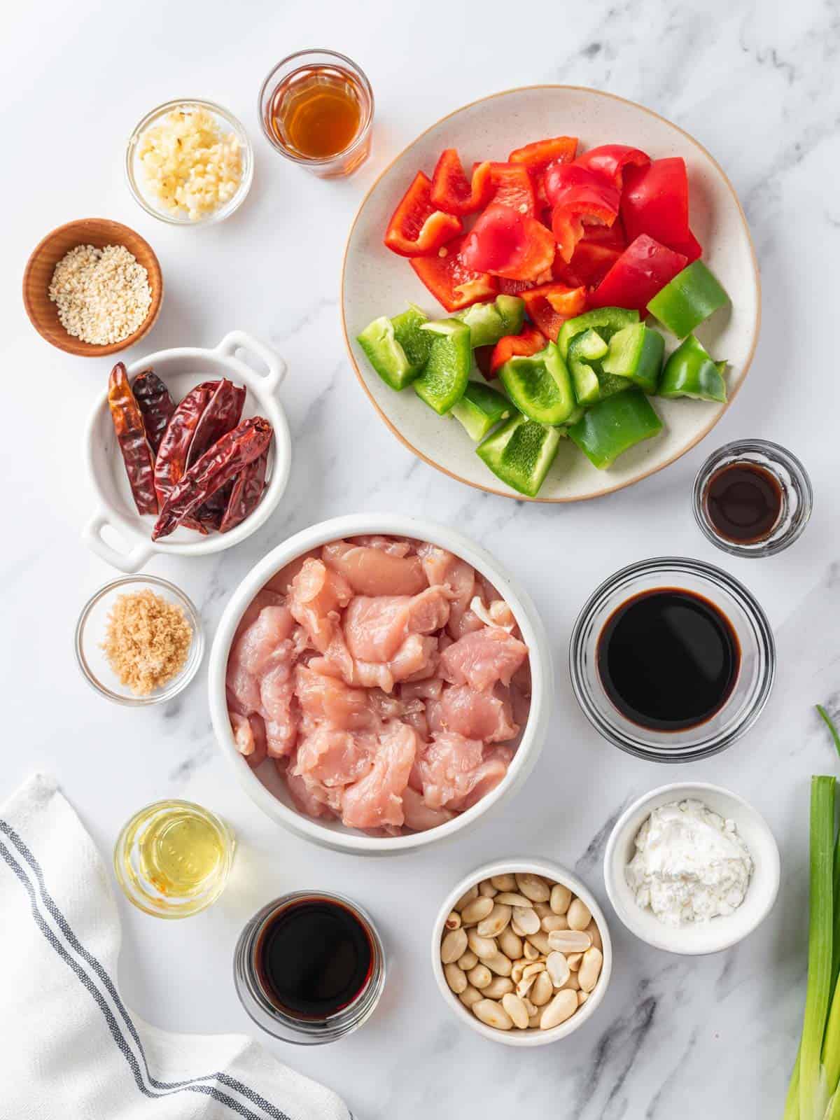 Chicken, bell peppers, dried chilies, peanuts, sauces, and other ingredients for Kung Pao chicken.