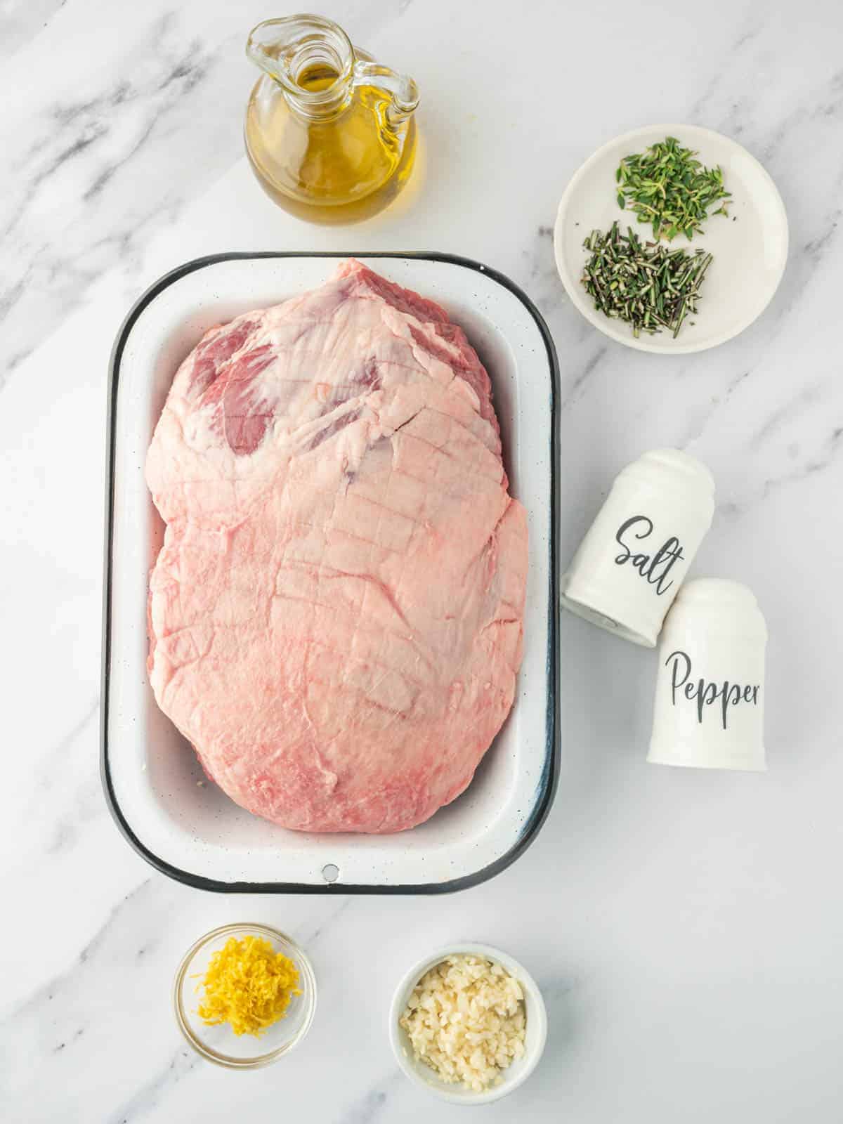 Boneless lamb leg with garlic, fresh herbs, lemon zest, olive oil, salt, and pepper.