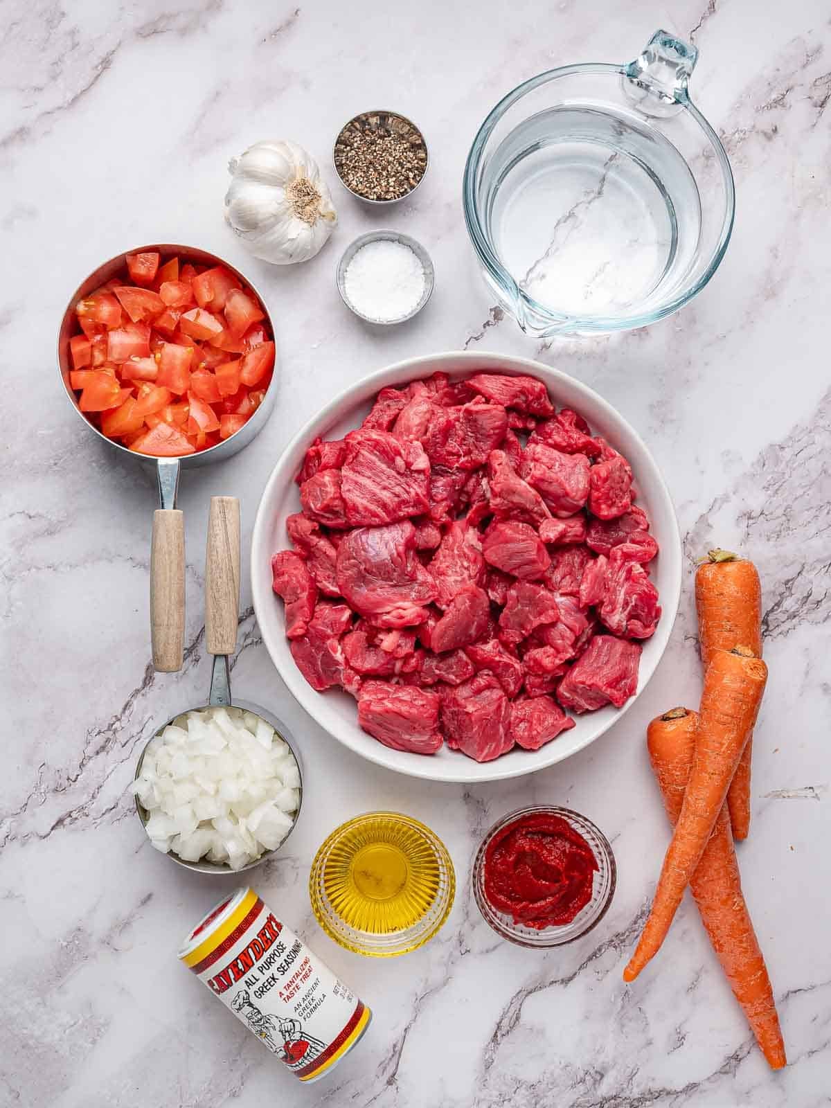 Beef, tomatoes, carrots, onion, garlic and seasonings for Tomato Beef Stew.