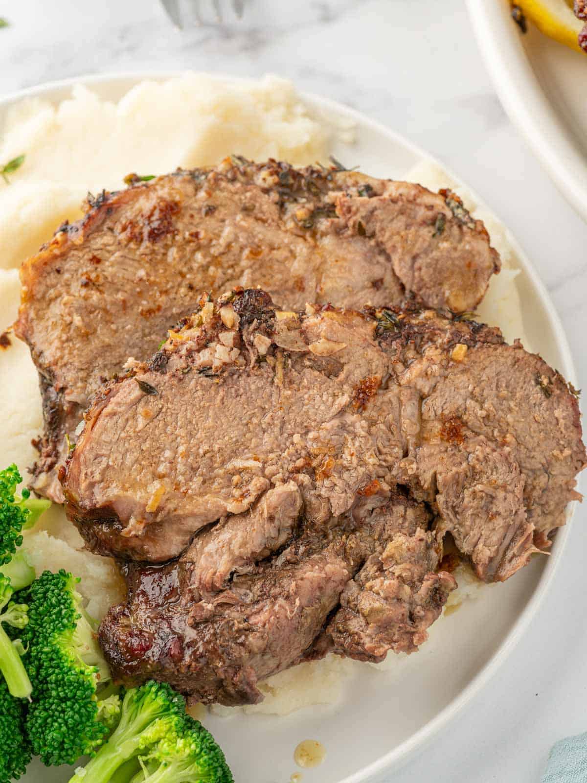 Slices of garlic and herb lamb served over mashed potatoes.