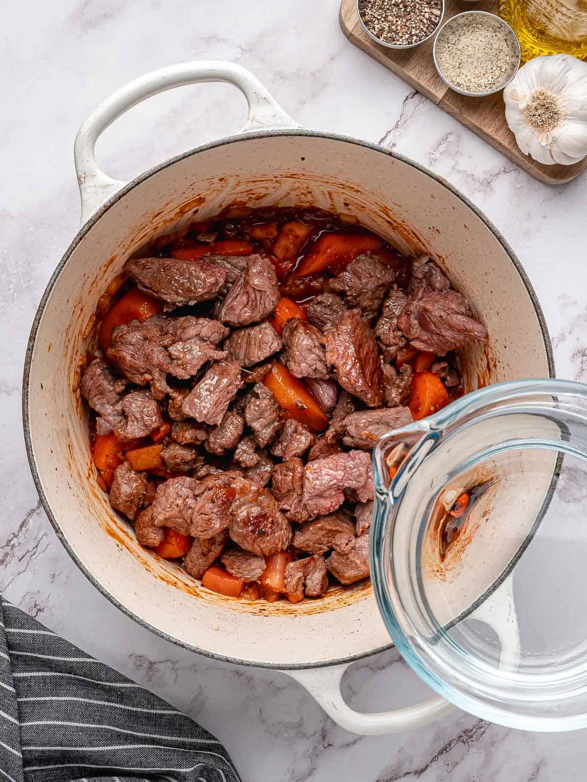 Water added to the browned beef, carrots, and tomato mixture.