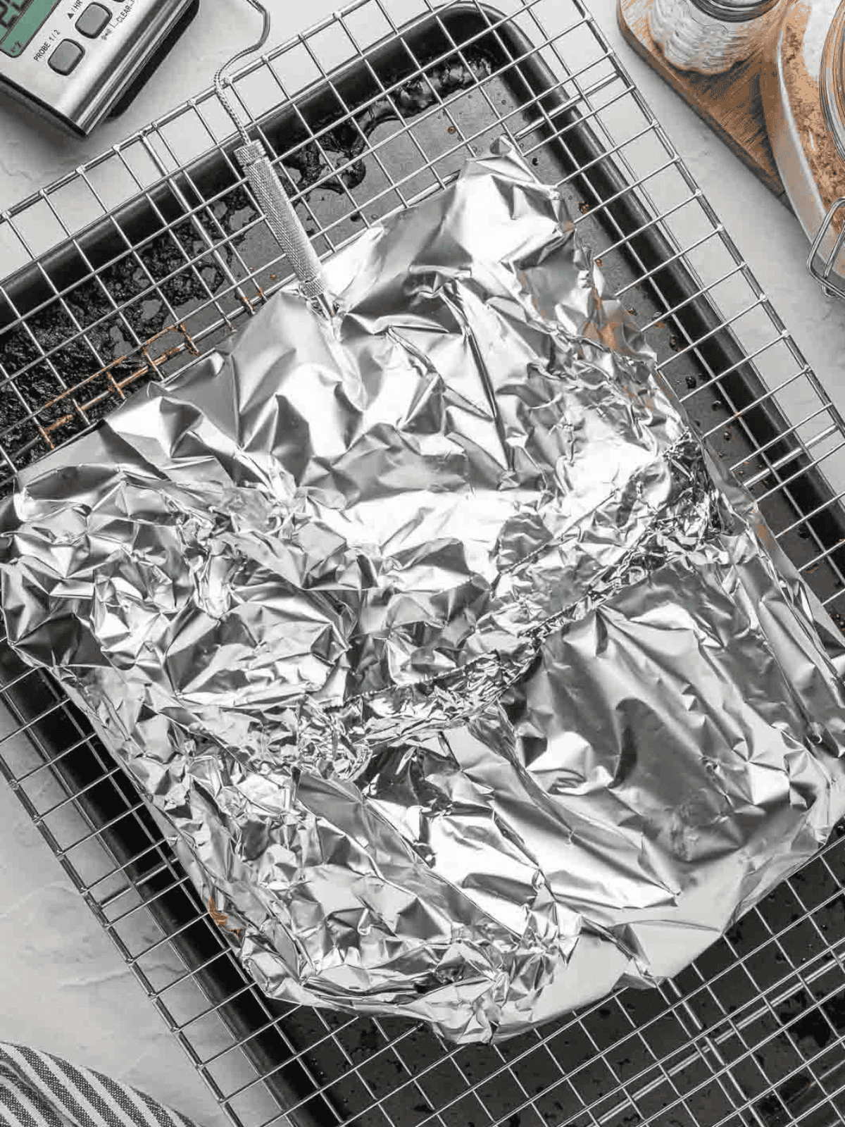 Beef brisket wrapped tightly in aluminum foil during baking.