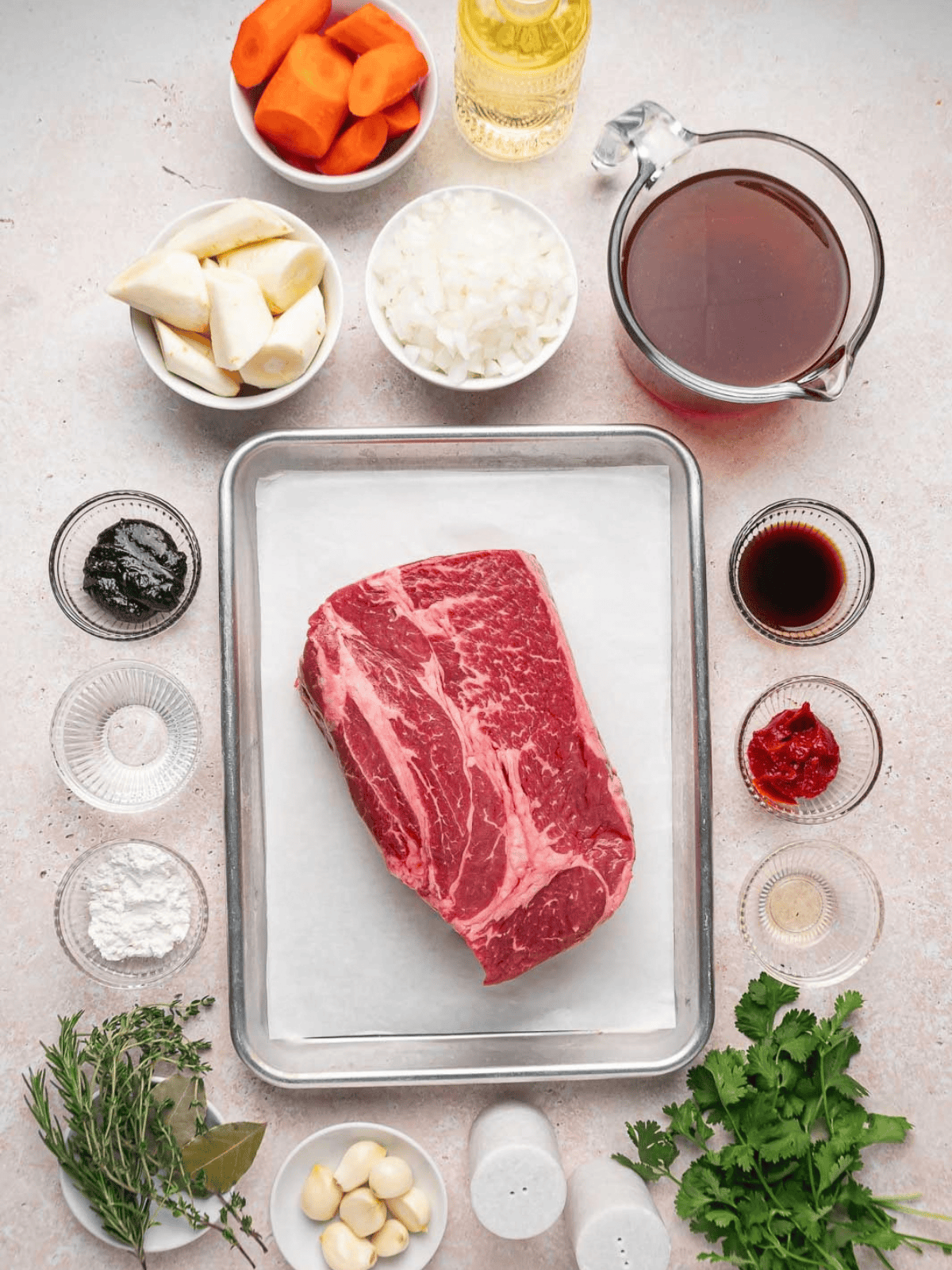 Ingredients for Dutch Oven Pot Roast arranged around a boneless chuck roast.
