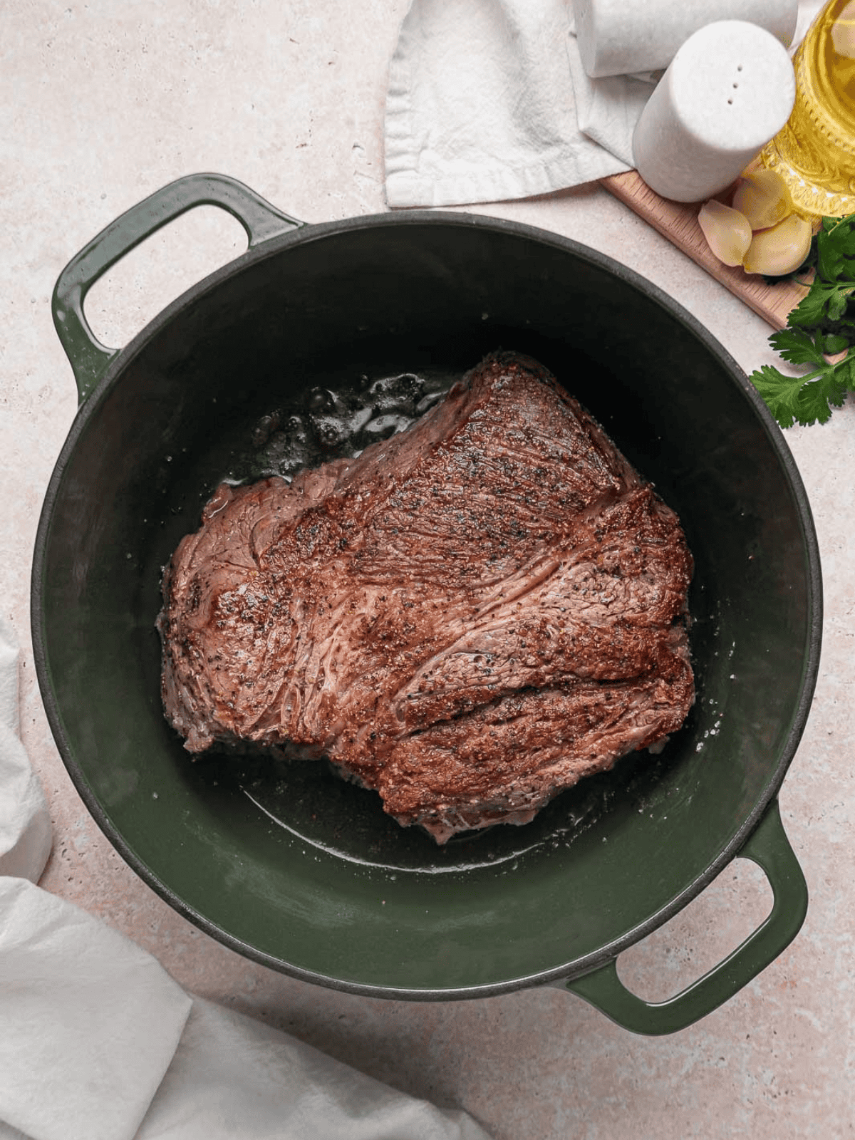 Chuck roast browned on both sides in a Dutch oven.