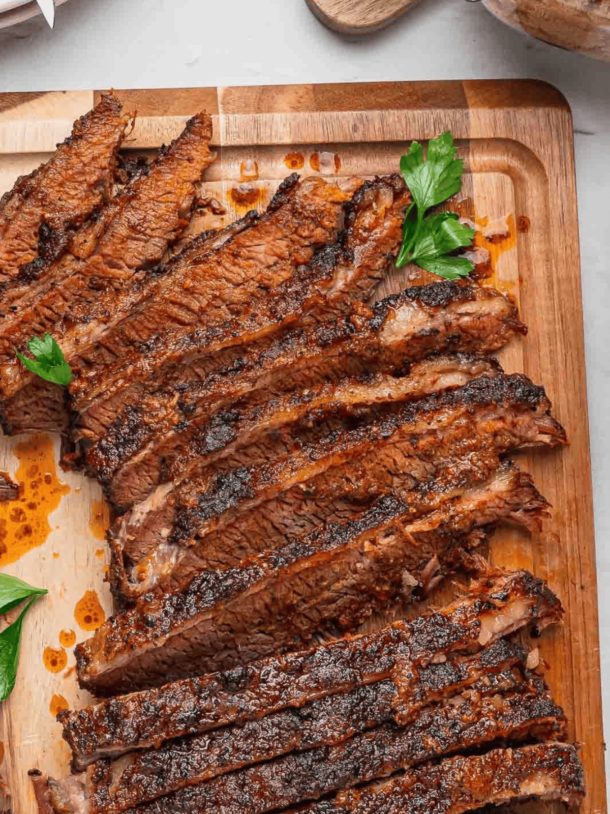 Tender brisket slices with a dark seasoned crust and cooking juices.